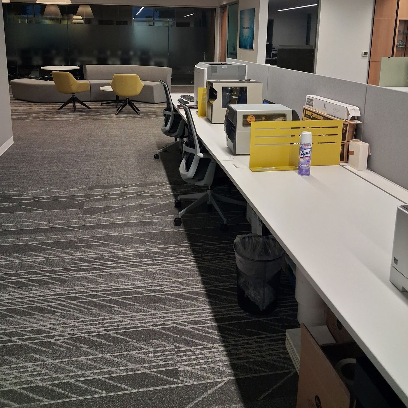 Office workstations and floors after a commercial cleaning visit, bins emptied and surfaces cleared